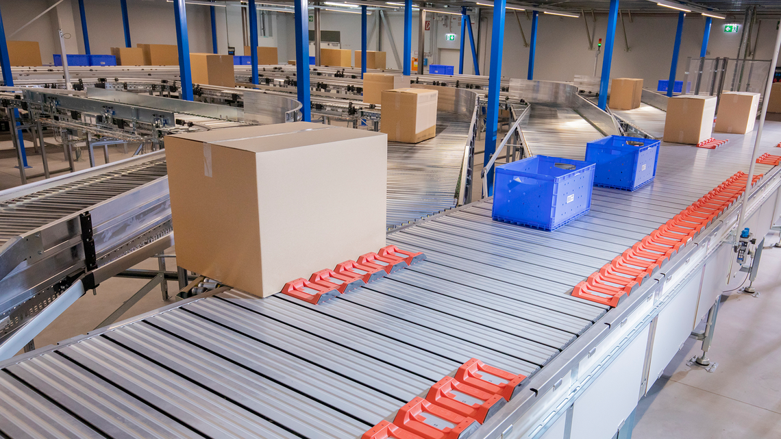 Cartons and totes traveling down the TGW Logistics Natrix sorting system where the goods will be sorted and diverted to the next working area