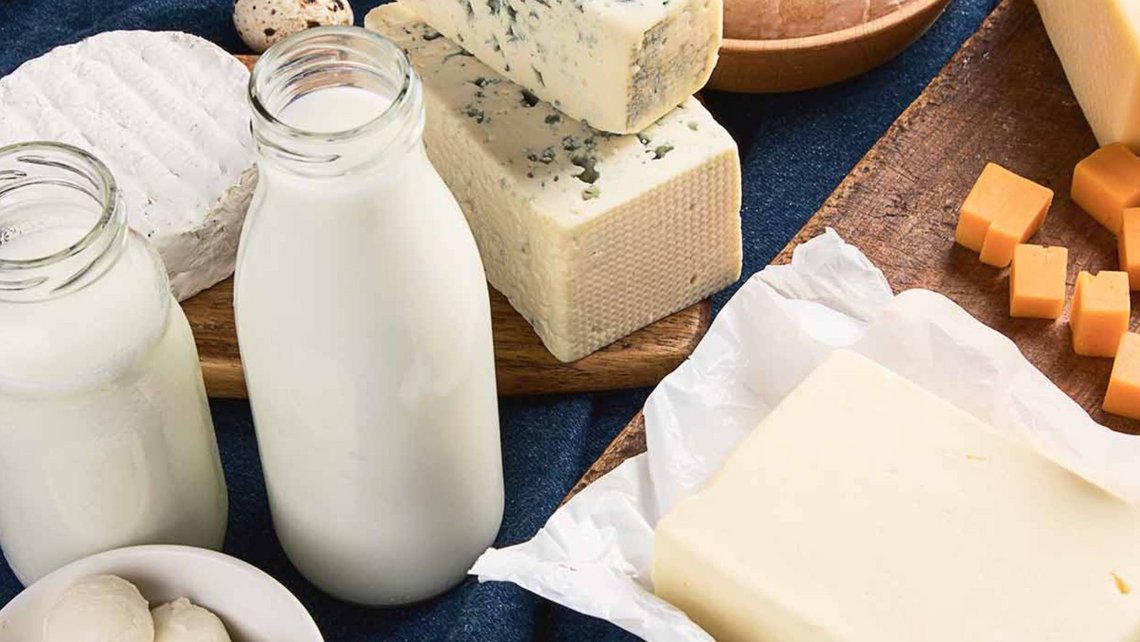 Mix of dairy products on a table with milk and a selection of cheeses