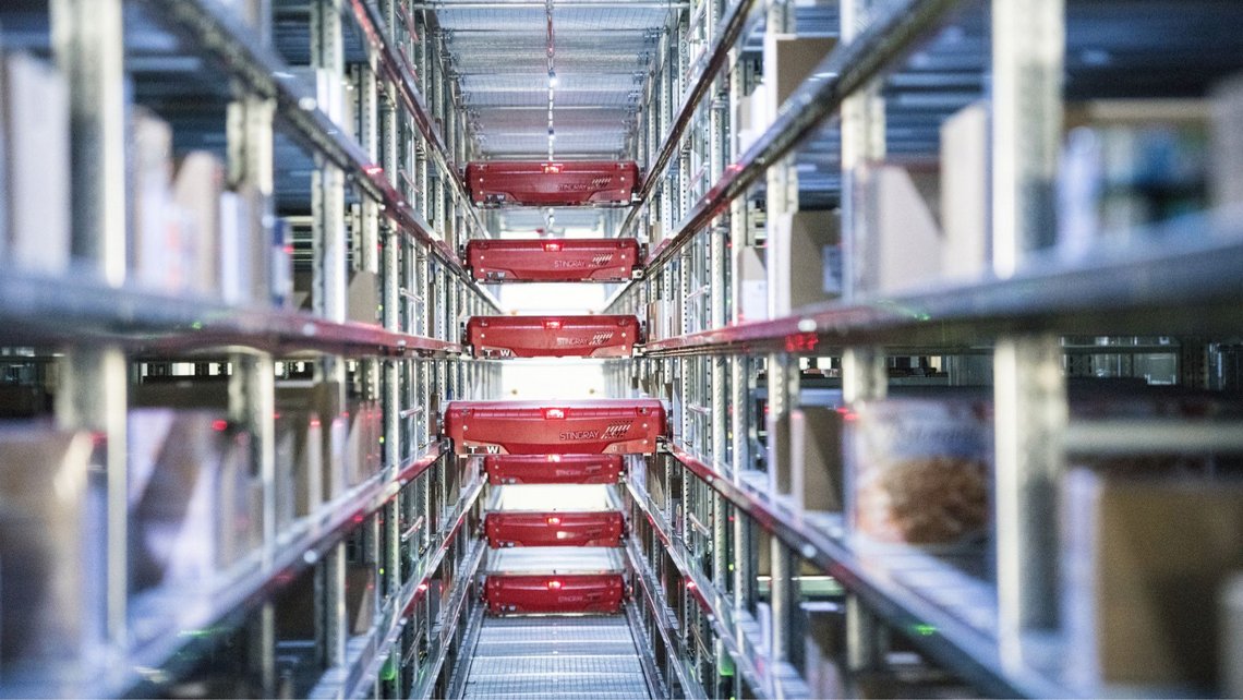 Aisle in a shuttle warehouse, on the right and left you can see the compartments in which goods are stored