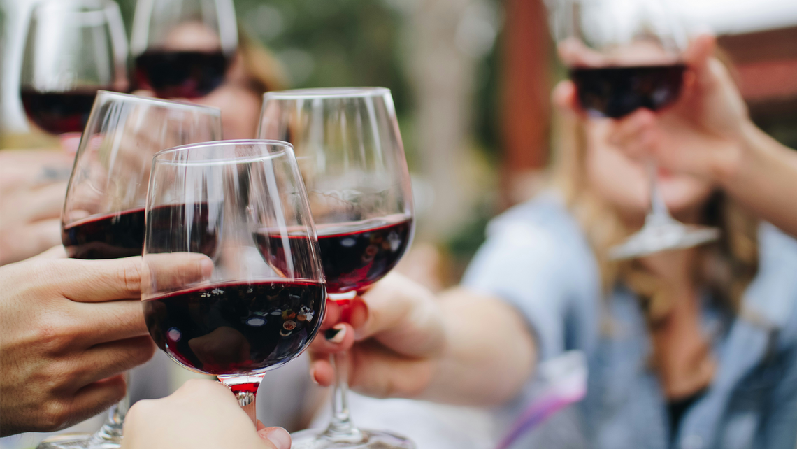 People clinking wine glasses together