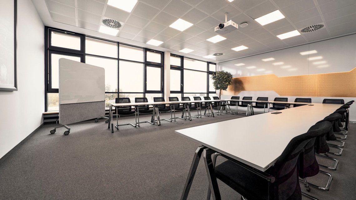 One of the meeting rooms at TGW robotics in Rohrdorf with the seats an tables in a U-formation