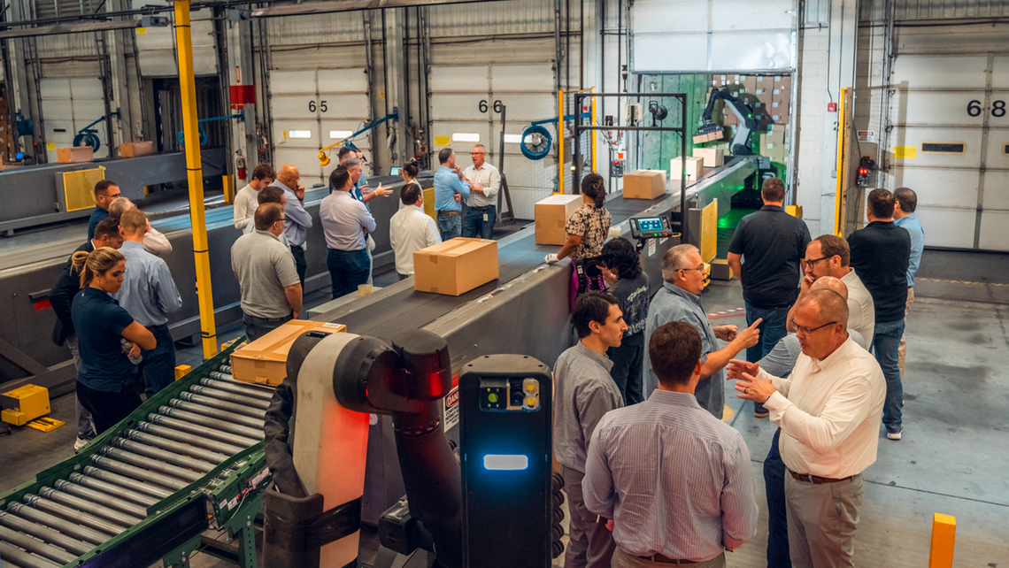 Attendees of Gap Campfire Talk observing the use of robotics to turn the TGW Logistics' One-Touch Receiving system into a no-touch operation for Gap's inbound logistics