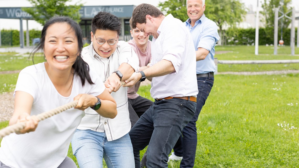 TGW Logistics colleagues playing tug of war in the activity garden in Marchtrenk, Austria