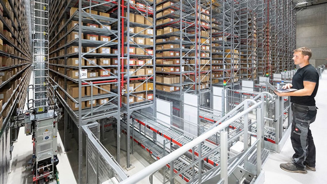 Man looking at the rackings with carboard boxes inside the Engelbert Strauss warehouse