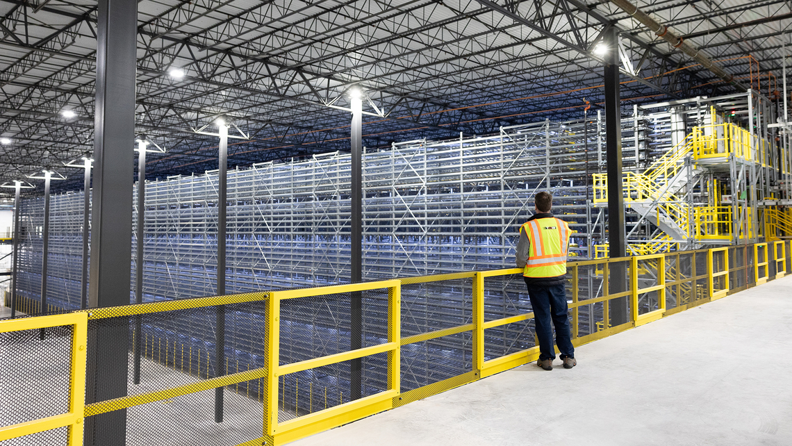 TGW Logistics on-site employee looking out at a customer's massive ASRS shuttle system