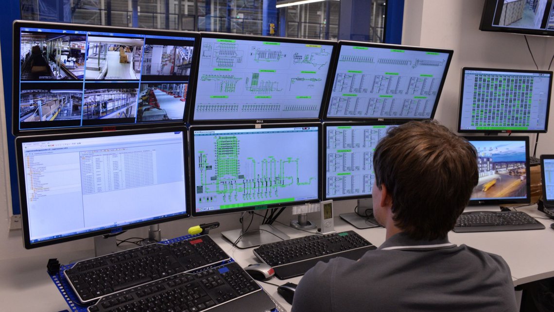  A person sitting in front of large screens