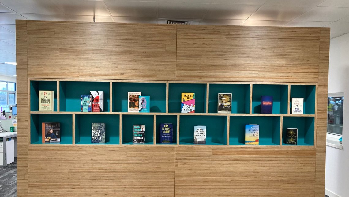 Wooden book case with blue shelfs and books on them