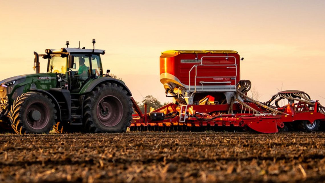 Agricultural appliances out on the field with a tractor pulling another appliance