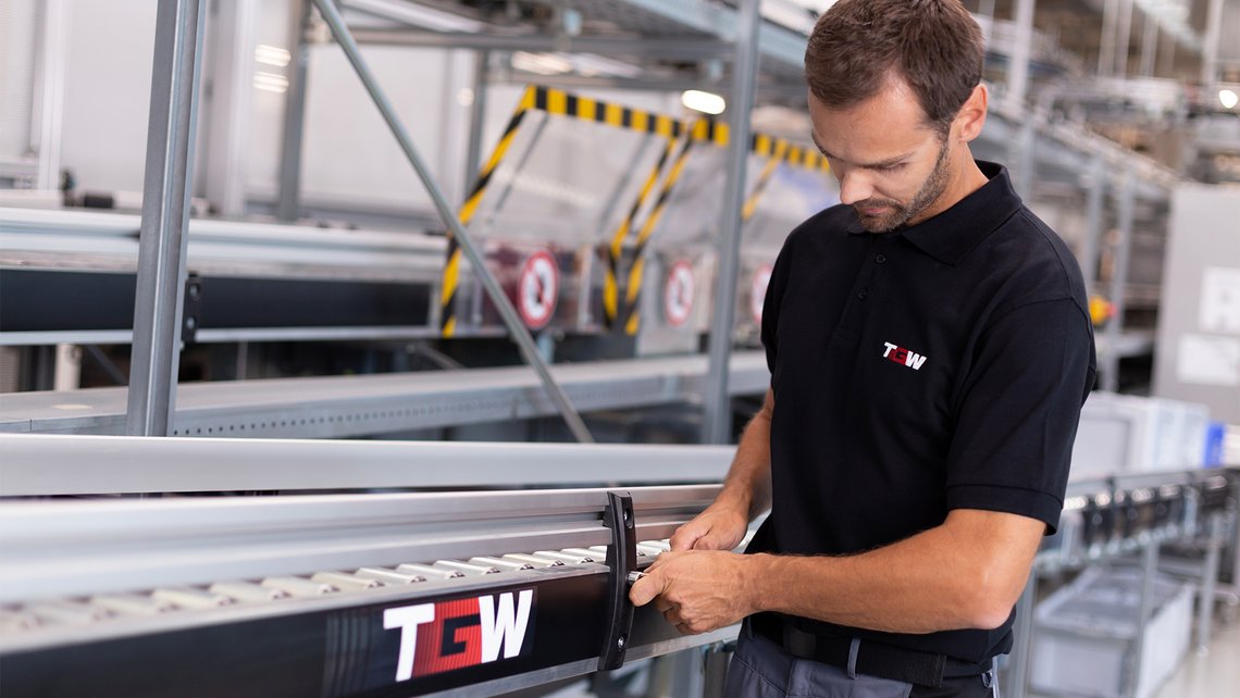 [Translate to Spain:] A man working on a conveyor