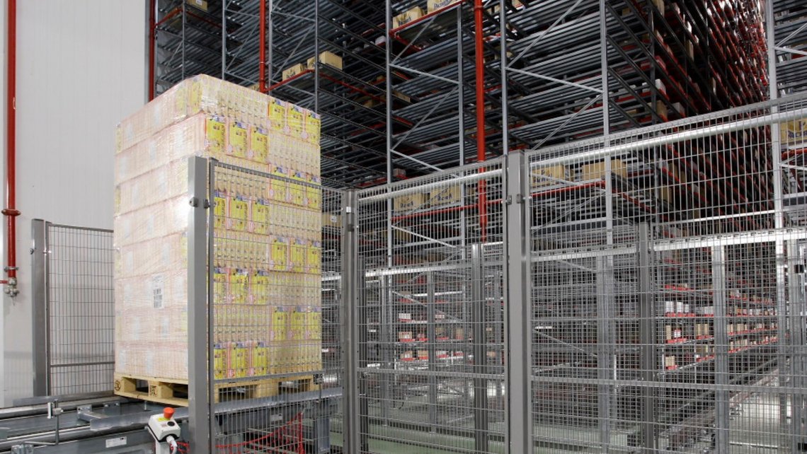 Pallets with boxes containing fresh goods in front of a high rack with other pallets