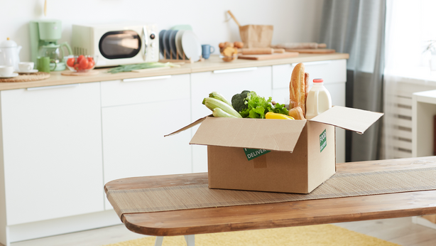 Box of delivered groceries on a kitchen table