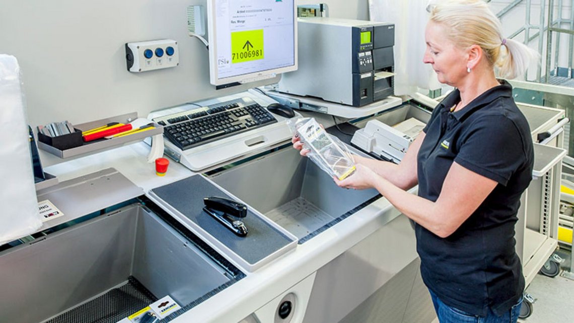 Woman picking from crates at a pickstation inside the Karcher distribution center