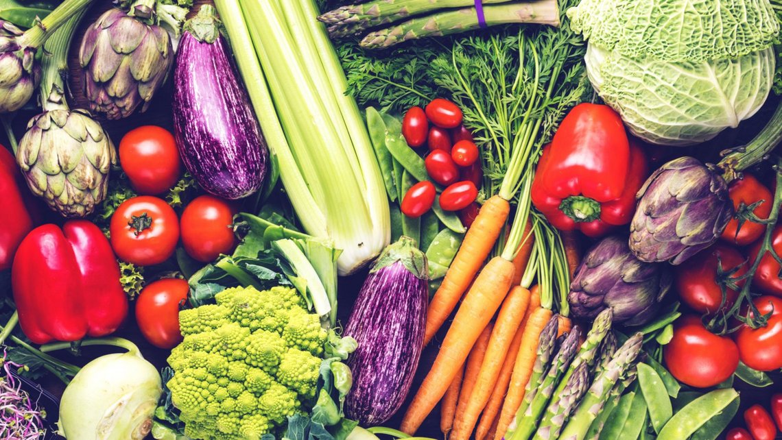 A vibrant assortment of fresh vegetables stacked high, showcasing a variety of colors and textures