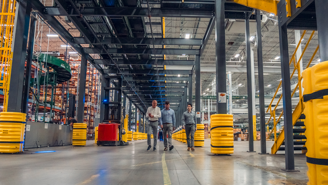 Attendees of Gap Campfire Talk walking under the mezzanine to get to another area of the logistics center