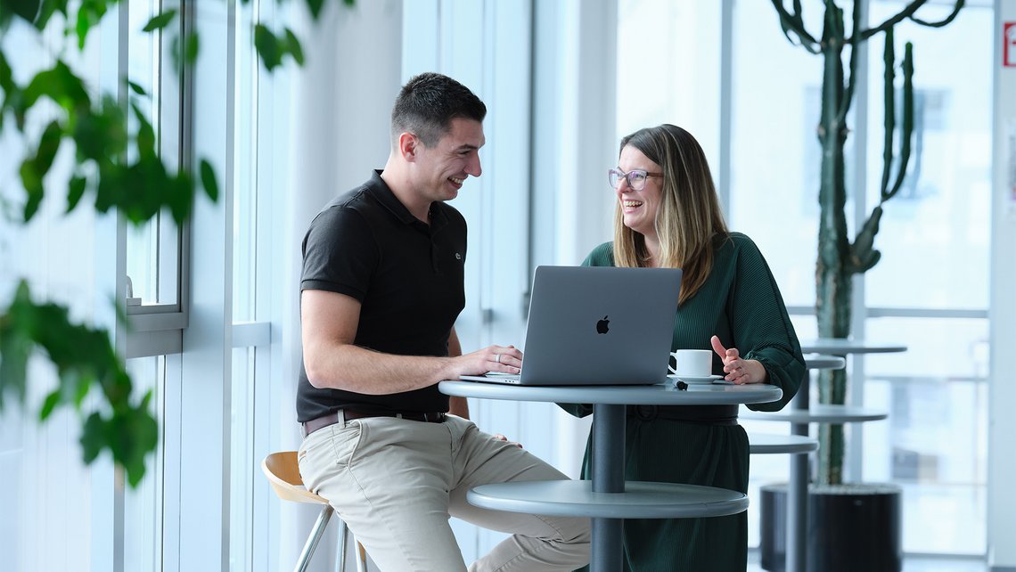 Two TGW Logistics employees having a conversation during their break at the office