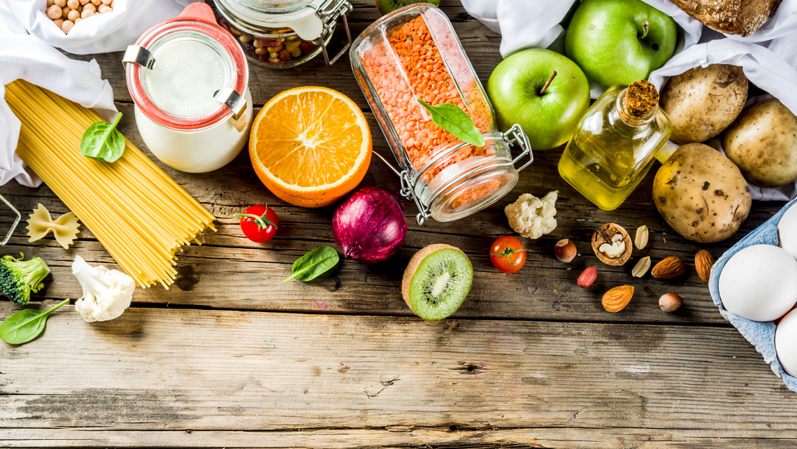 Various groceries scattered and displayed on a wooden table top