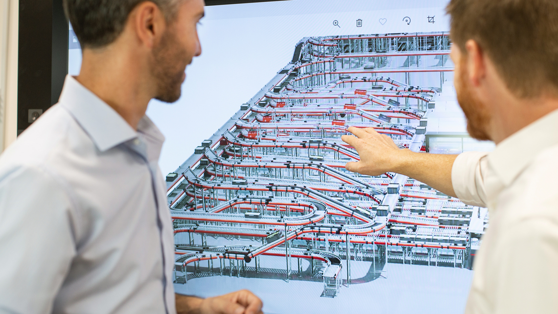 Two gentlemen reviewing an automated warehouse solution design as part of the TGW Logistics' systems integrator business