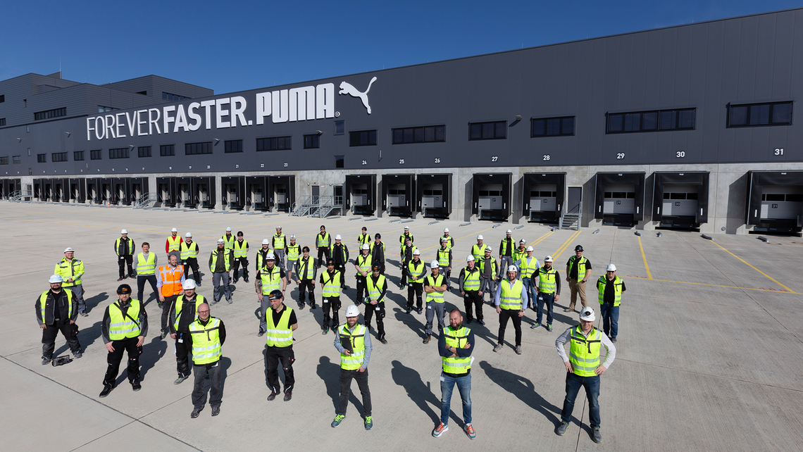 TGW Logistics' Lifetime Services on-site team outside of the Puma distribution center looking up at the camera